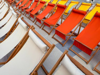 Beyaz, turuncu ve sarı kumaş koltukların yer aldığı açık hava sinema ortamında düzenlenmiş renkli iskemleler, canlı bir yaz atmosferi yaratıyor..