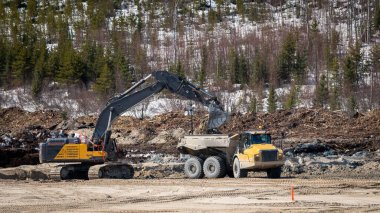 Çöpçüler kış aylarında ormanda kazı yaparken bir kazıcı tarafından dolduruluyor.