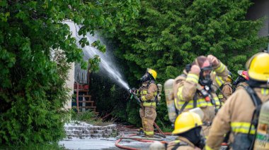 İtfaiyeci, bir grup itfaiyeciyle birlikte yangına karşı savaşıyor.