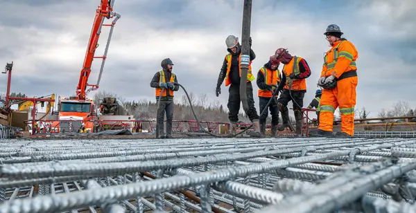 Rouyn-Noranda, Quebec, Kanada, 2022-11-25, işçiler kış boyunca beton bir pompa kullanarak köprü için beton bir levha inşa ediyorlar.