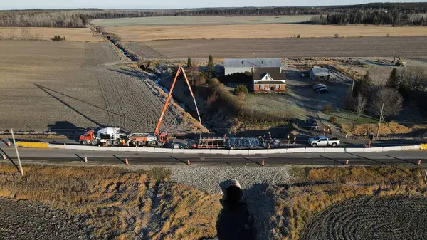 Nedelec, Quebec, Kanada, 2021-11-10, Beton pompa bir taşra yolunda zayıflatılmış bir kanaldan acil durum levhası için beton döküyor