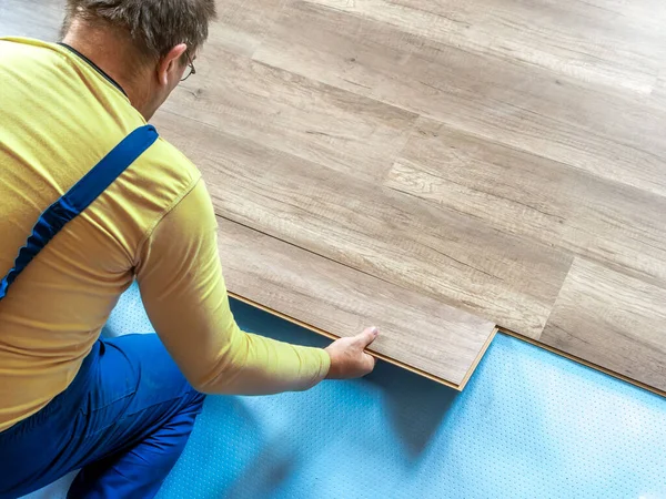 一个木匠在房间内铺设新的层压板地板 — 图库照片
