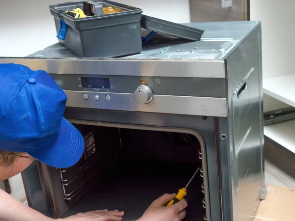 Servicemann Demontiert Teile Des Elektrobackofens Für Einfachen Reparaturzugang — Stockfoto