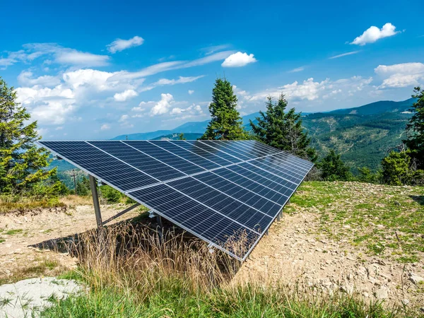 Solar panel station mounted on a mountain slope, with beautiful panorama of Beskid Zywiecki mountains in the background, Poland