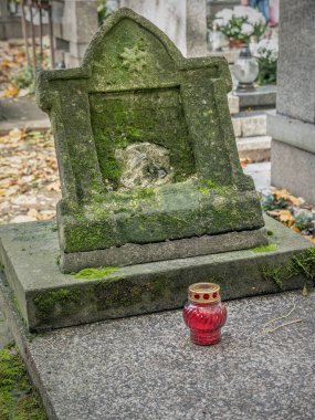 Unutulmuş eski bir mezar taşı ve bir adak mumu