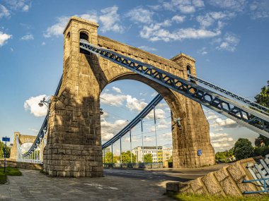 Grunwald Köprüsü 'nün büyük bir süspansiyonu, tarihi mimarisi parlak mavi gökyüzü altında zarafetle uzanıyor, Wroclaw, Polonya