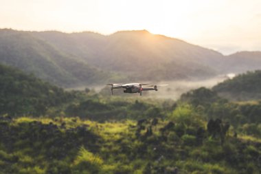 İnsansız hava aracı yüksek çözünürlüklü dijital kamera dağ, orman manzarası ve güzel günbatımı ile uçuyor.