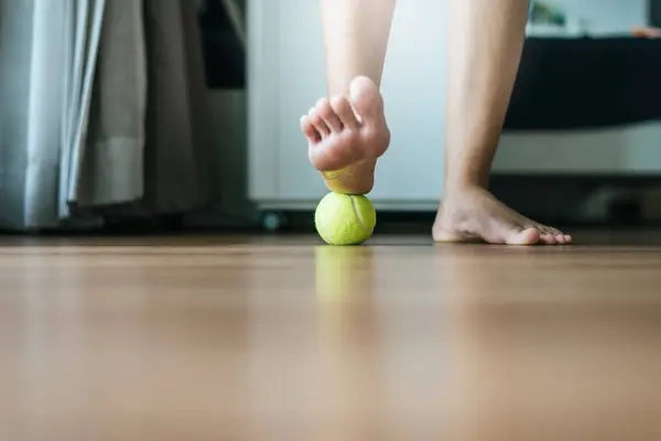 Woman massaging with tennis ball on foot,Feet soles massage for plantar fasciitis