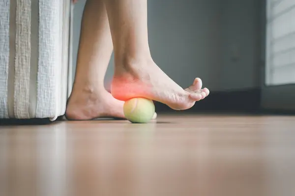 Woman massaging with tennis ball on foot,Feet soles massage for plantar fasciitis
