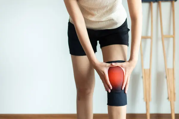 Patient woman using knee support brace at physical therapy center