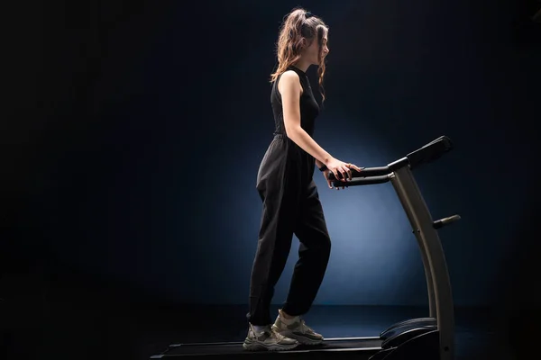 一个漂亮的女运动员在健身俱乐部的跑步机上跑步 有氧运动训练 健康的生活方式 — 图库照片