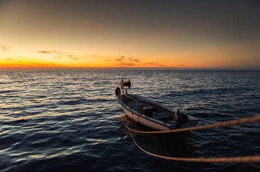 Balıkçı teknesi rıhtımda ve gün batımında 
