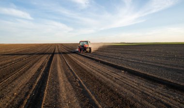 Traktörlü bir çiftçi güneş batarken tarlasını hazırlar.. 