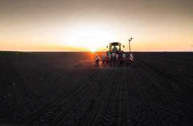 Traktör tohumu olan çiftçi - ilkbaharda tarım tarlalarına ekin ekiyor.
