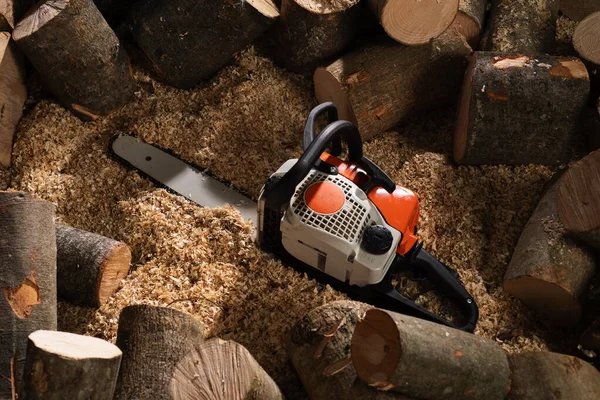Modern chain saw and  firewood,closeup