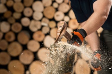 Hand and axe in firewood, chopping wood for fire heat 