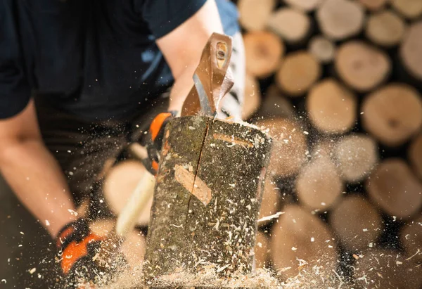 Hand and axe in firewood, chopping wood for fire heat 