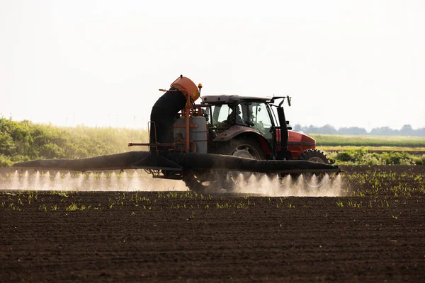 散布機で畑に農薬を散布するトラクター — ストック写真
