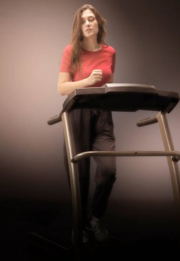 Güzel bir atletik kız spor salonunda koşu bandında koşuyor. Konsept: kardiyo eğitimi, ağırlık, sağlıklı yaşam tarzı.