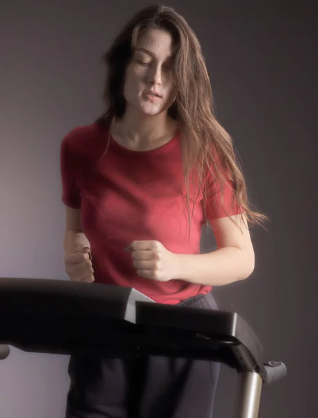 一个漂亮的女运动员在健身俱乐部的跑步机上跑步 有氧运动训练 健康的生活方式 — 图库照片