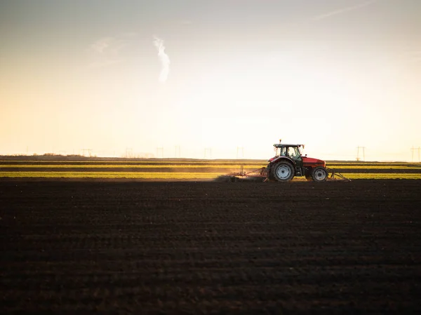 当太阳落山时 拖拉机上的农民正在准备田地 — 图库照片