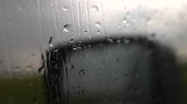 Yağmur sırasında arabanın camından bir görüntü. Ayna yansıması