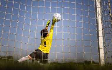 Genç bir kaleciyle futbol golü. Gençlik futbolu kalecisi