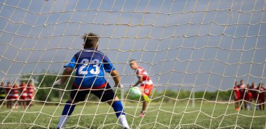 Genç çocuk kaleci bir futbol futbol oyununda kaydetme.