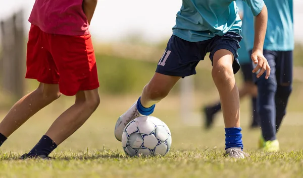 子供のためのサッカーの試合 スポーツフィールドでボーイズランニングとキッキングフットボール 2人の若者サッカー選手がサッカーボールで競う ロイヤリティフリーのストック写真