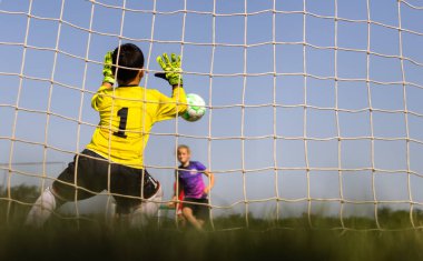 Soccer goal with a young boy goalkeeper. Youth football goalkeeper save clipart