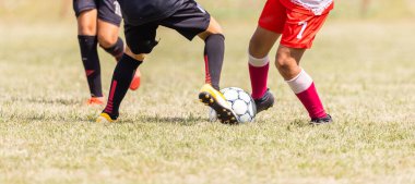 Çocuklar için futbol maçı. Spor sahasında koşan ve futbol oynayan çocuklar. İki Genç Futbolcu Futbol Topu İçin Yarışıyor