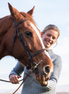 Genç bayan dışarıda atına bakıyor..