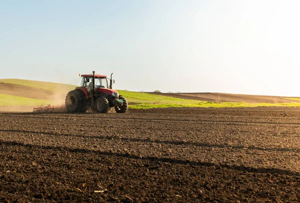 A farmer on a tractor processes a farm field.  Preparing the land for a new crop planting