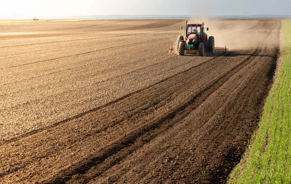 A farmer on a tractor processes a farm field.  Preparing the land for a new crop planting