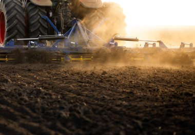 Traktör sürme çiftliği akşam yeni ekin ekimi için toprağı hazırlıyor..