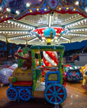 Gece boyunca Luna parkında renkli bir dönme dolap. Dönme dolabın uzun pozlu dikey fotoğrafı. 