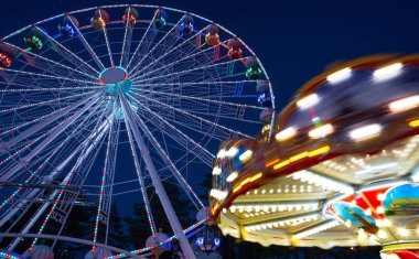 Gece boyunca Luna parkında renkli bir dönme dolap. Dönme dolabın uzun pozlu yatay fotoğrafı.. 