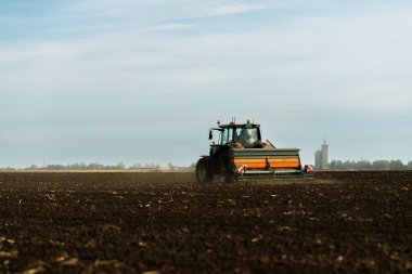 Traktör tohumu eken bir çiftçi. Tarım tarlasına ekin ekiyor. Bitkiler, buğday.