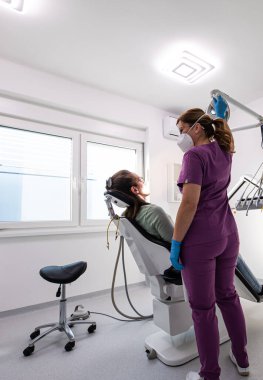 Diş hekimi hasta için ekipman hazırlar. Dişçi kürsüsüne beyaz atanması.