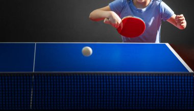 Tenis salonunda masa tenisi oynayan küçük kız..