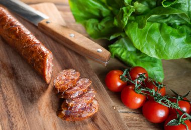 Kesme tahtasında kurutulmuş domuz sosisi. Üst görünüm.