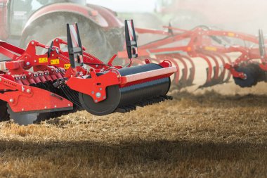 Agricultural equipment  standing in a field. Start tillage after harvest. clipart