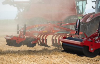 Agricultural equipment  standing in a field. Start tillage after harvest. clipart