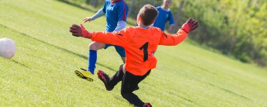 Genç çocuk kaleci bir futbol futbol oyununda kaydetme.