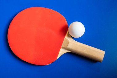İki masa tenisi raketi ve topları mavi bir masada ağlı..