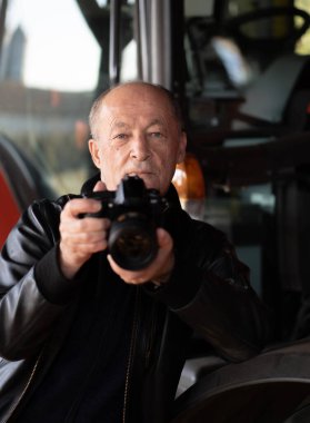 Mutlu kıdemli adam dijital kamerayla fotoğraf çekerken... 