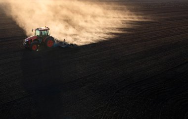 Traktör sürme çiftliği akşam yeni ekin ekimi için toprağı hazırlıyor..