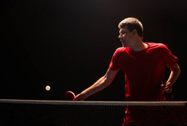 Bir masa tenisçisinin topu geri götürmesi.