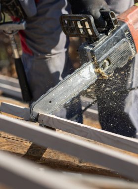 Sanayi inşaat işçisi elektrikli testere ile kereste kesiyor..