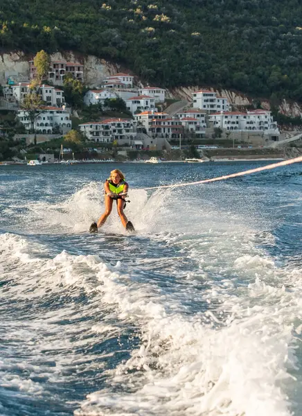 Gün batımında denizde su kayağı yapan genç bir kadın..